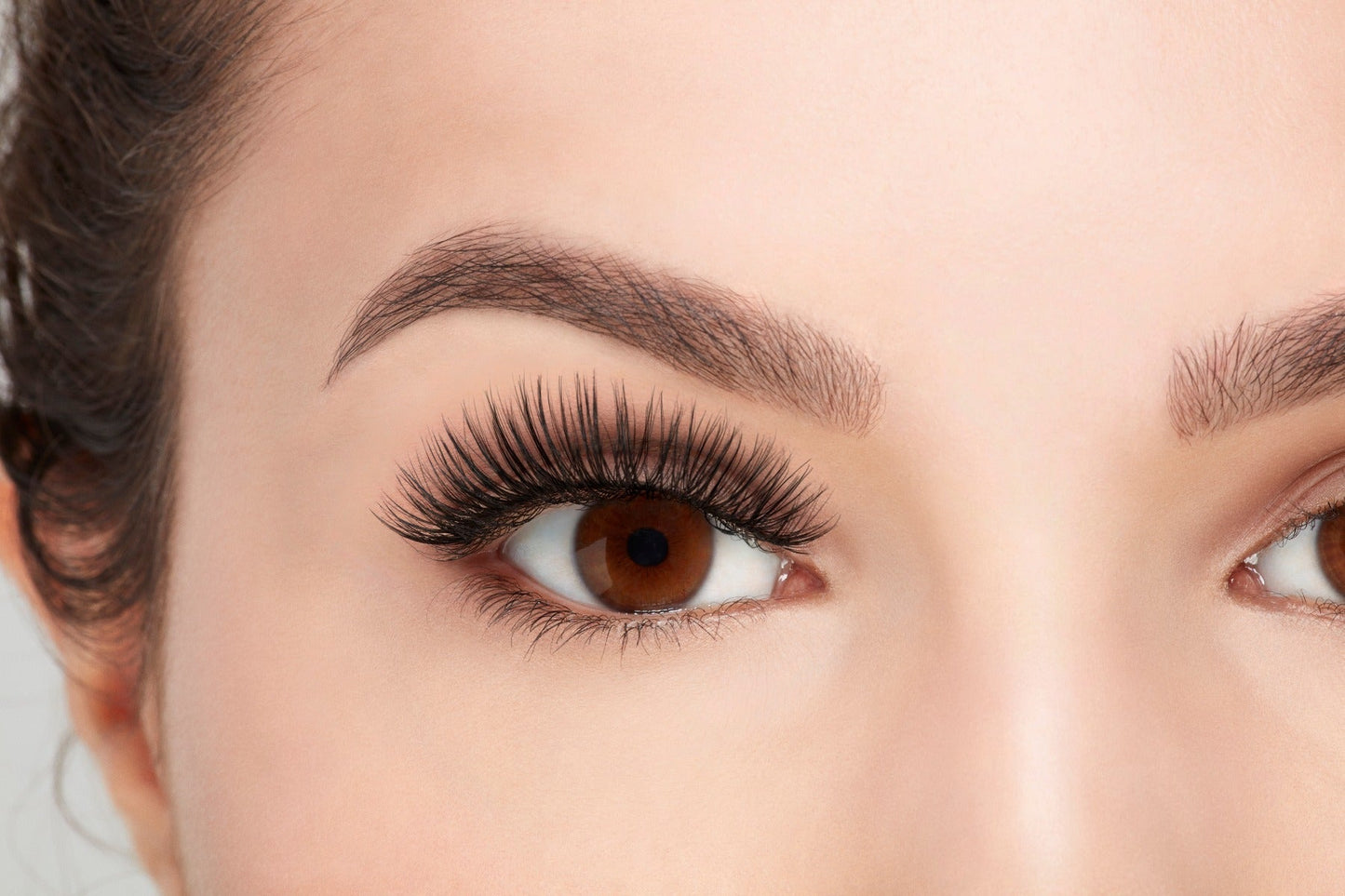 A model wearing Ardell's Faux mink 817 with open right eye showing its flared, winged-out & natural lash look