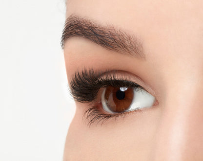 An extreme side close up shot of an eye wearing a Fauxmink 815 by Ardell creating a wide, full & natural eyelash look